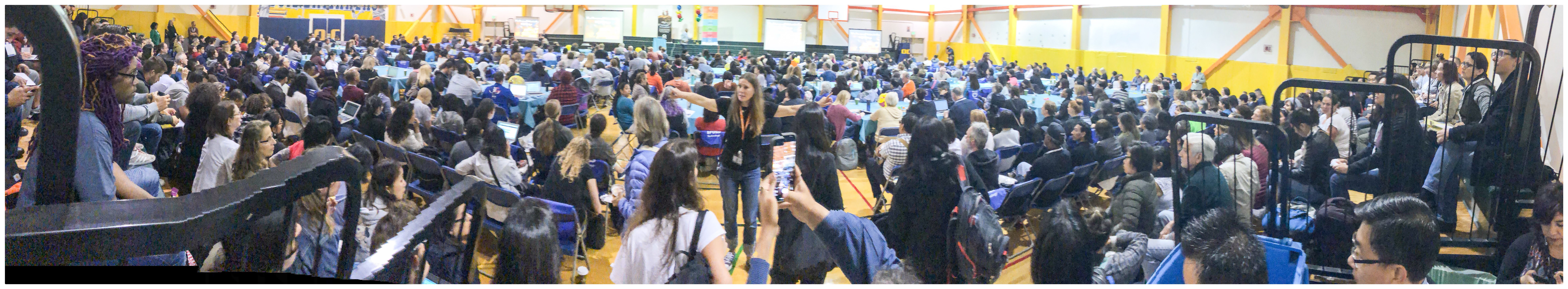 Panoramic view of attendees gathered for a community training event in a gymnasium